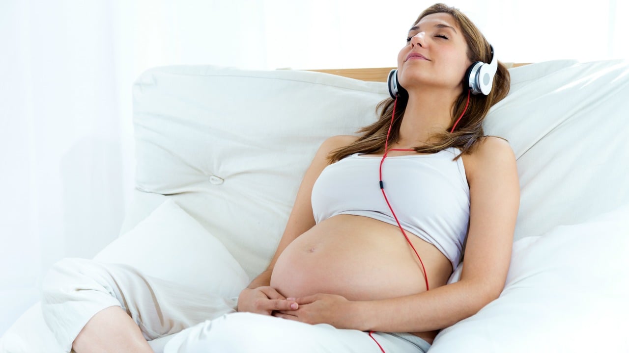müzik dinleyen hamile kadın